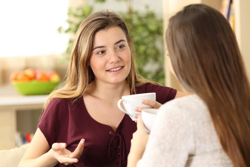 Two girls chatting over a cup of tea.