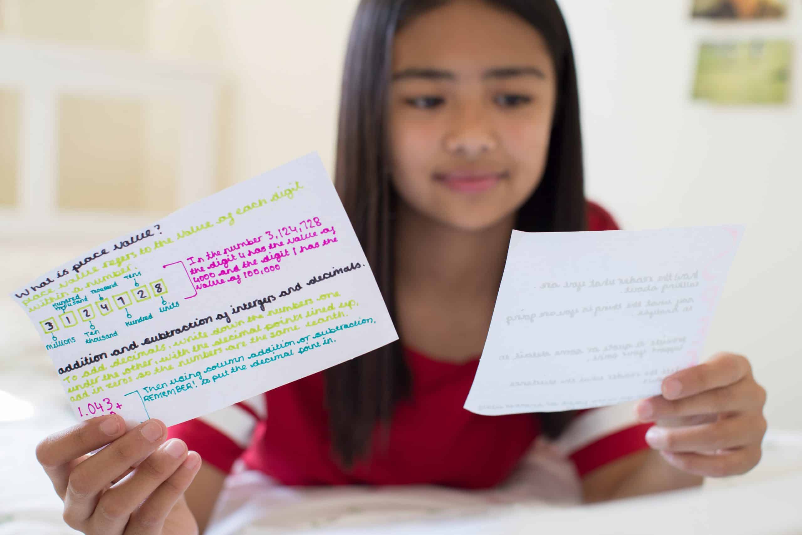 A young girl studying using flashcards.