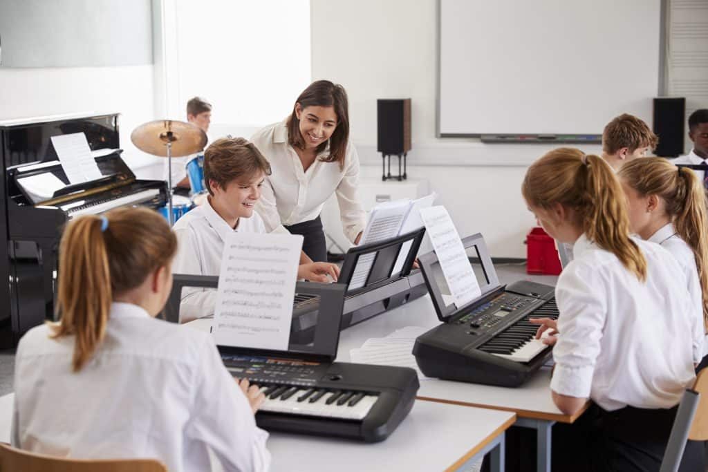 A female music teacher and her secondary school class.