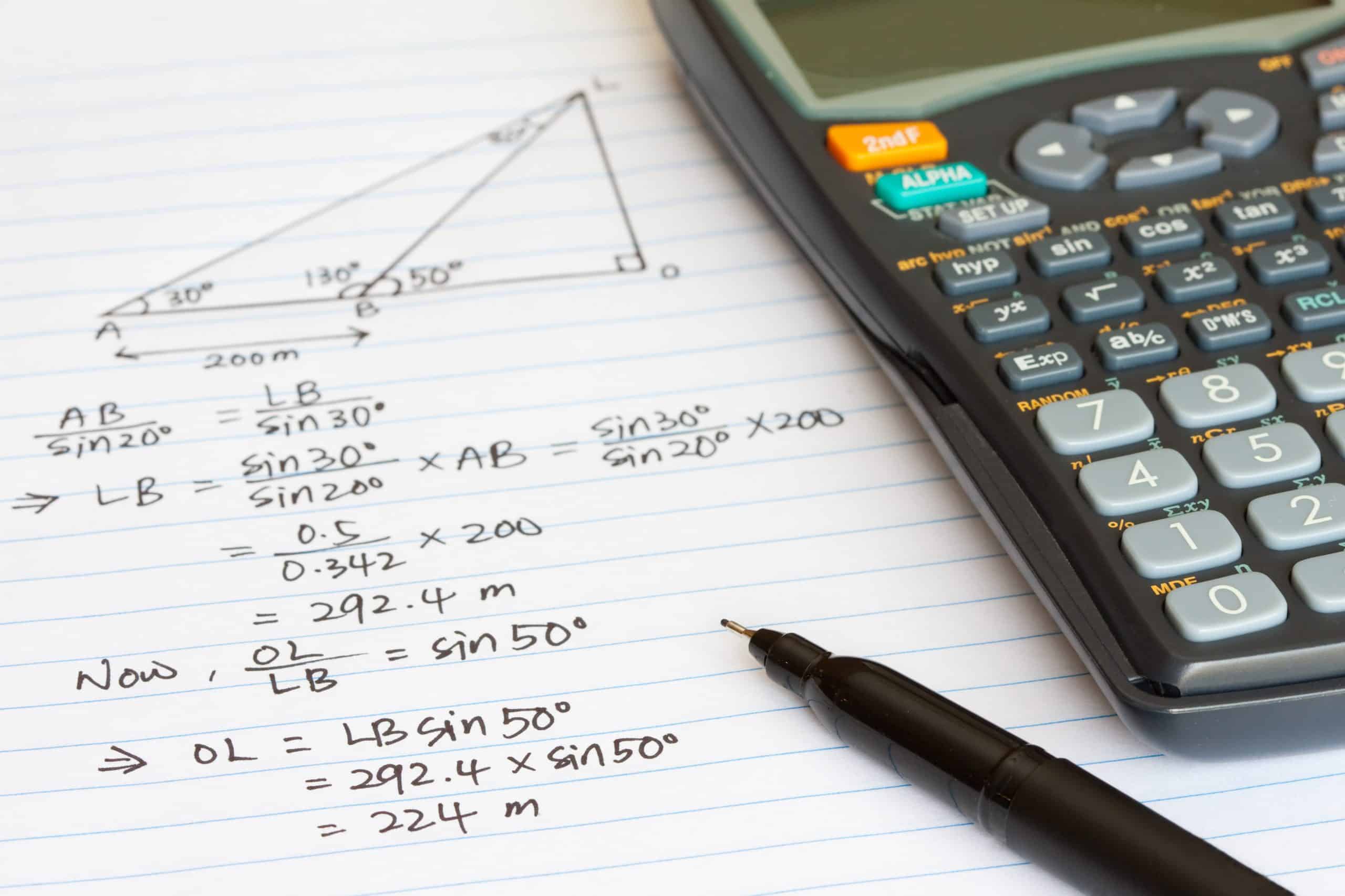 Calculator and pen on an open GCSE maths exercise book.